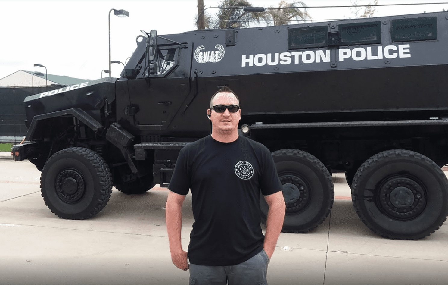 A man standing in front of an armored vehicle.
