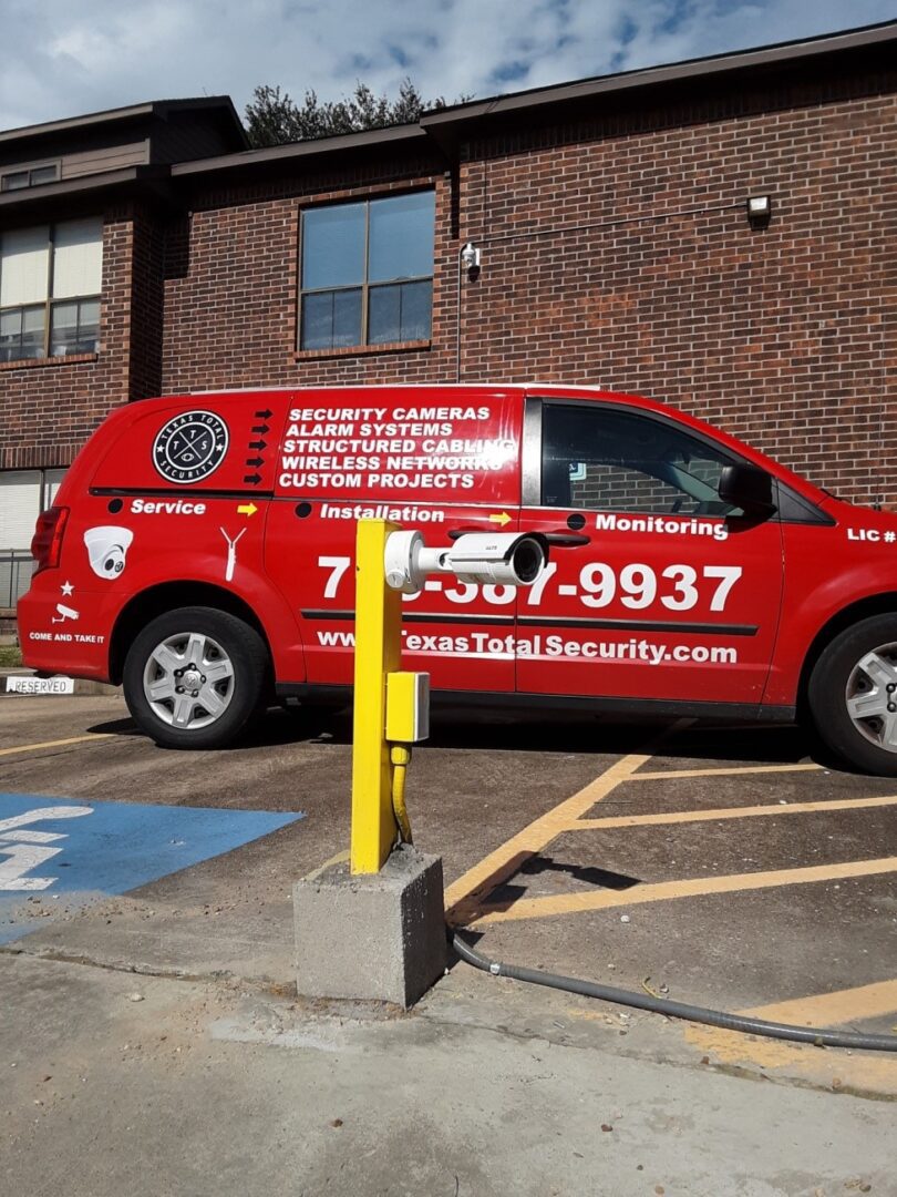 A red van parked in the parking lot of a building.