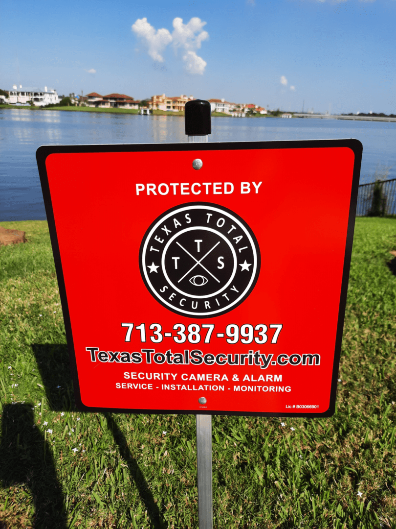 A red sign is posted on the side of a lake.